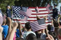 Crowd holding small American flags.